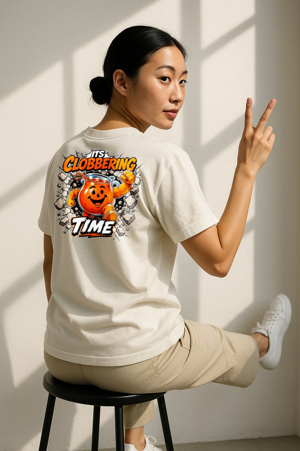 Man wearing orange and white It's Clobbering Time comic-style graphic tee, casual everyday outfit
